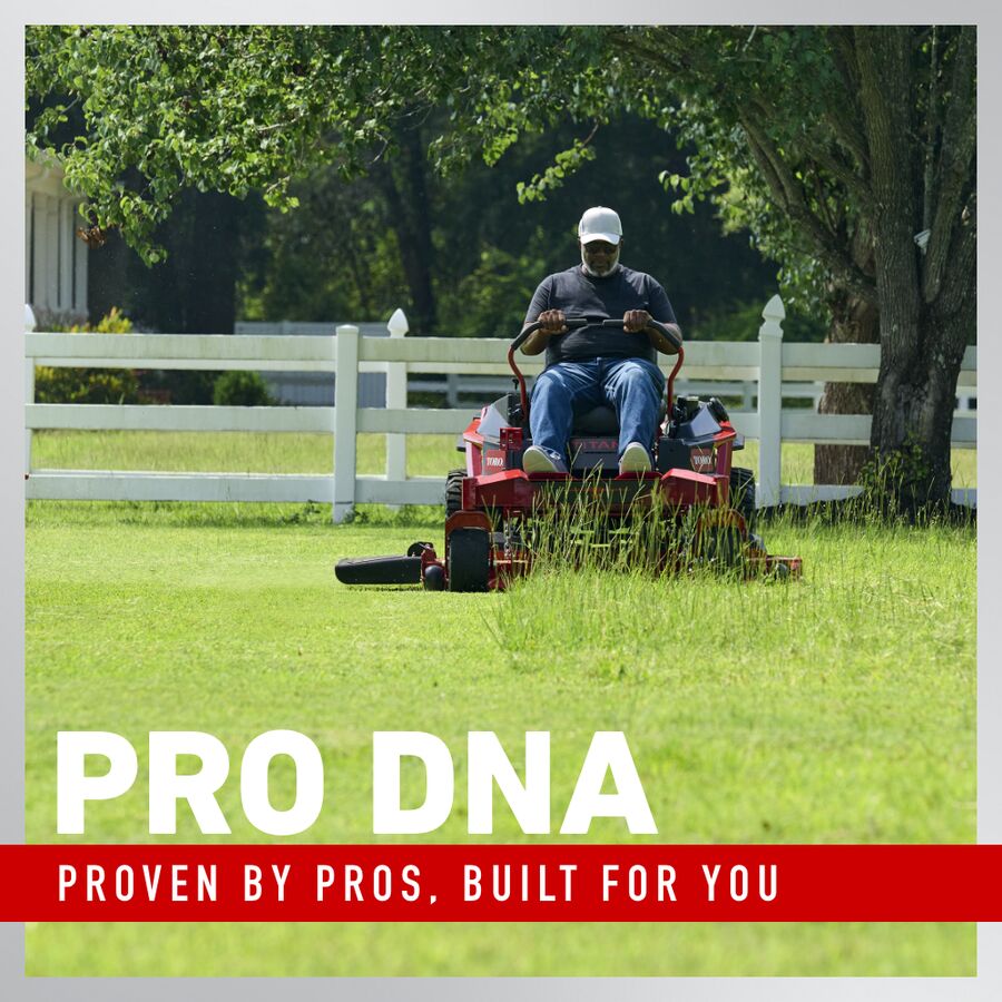 Man operating a lawn mower in a grassy area with trees and a white fence in the background, featuring the 'Pro DNA' brand text.