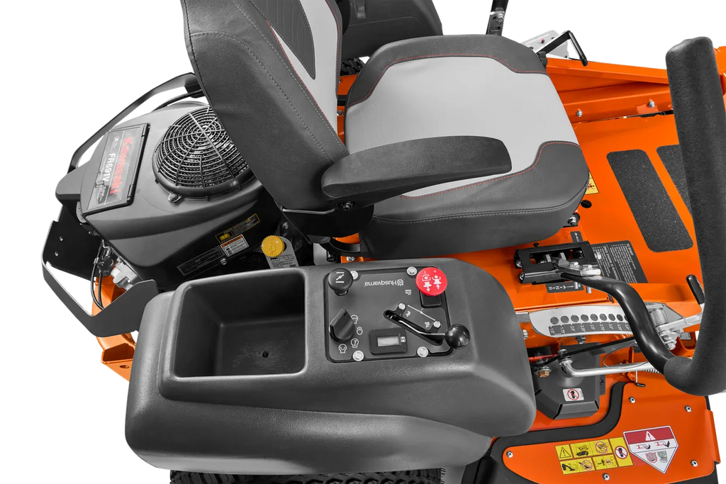 Close-up of a lawn mower seat and control panel on an orange machine.